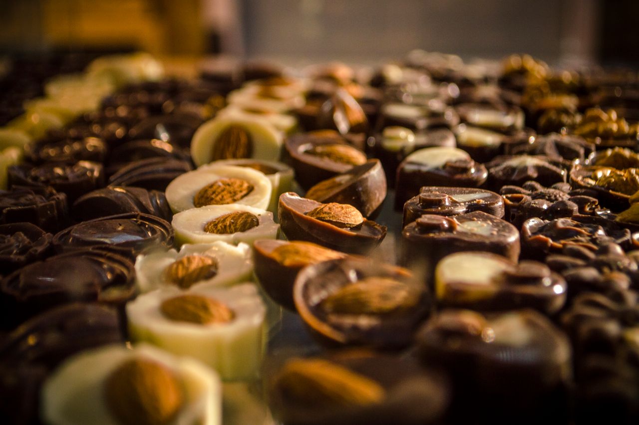 Services Close-up of assorted handmade gourmet chocolates with almonds set on a display table.